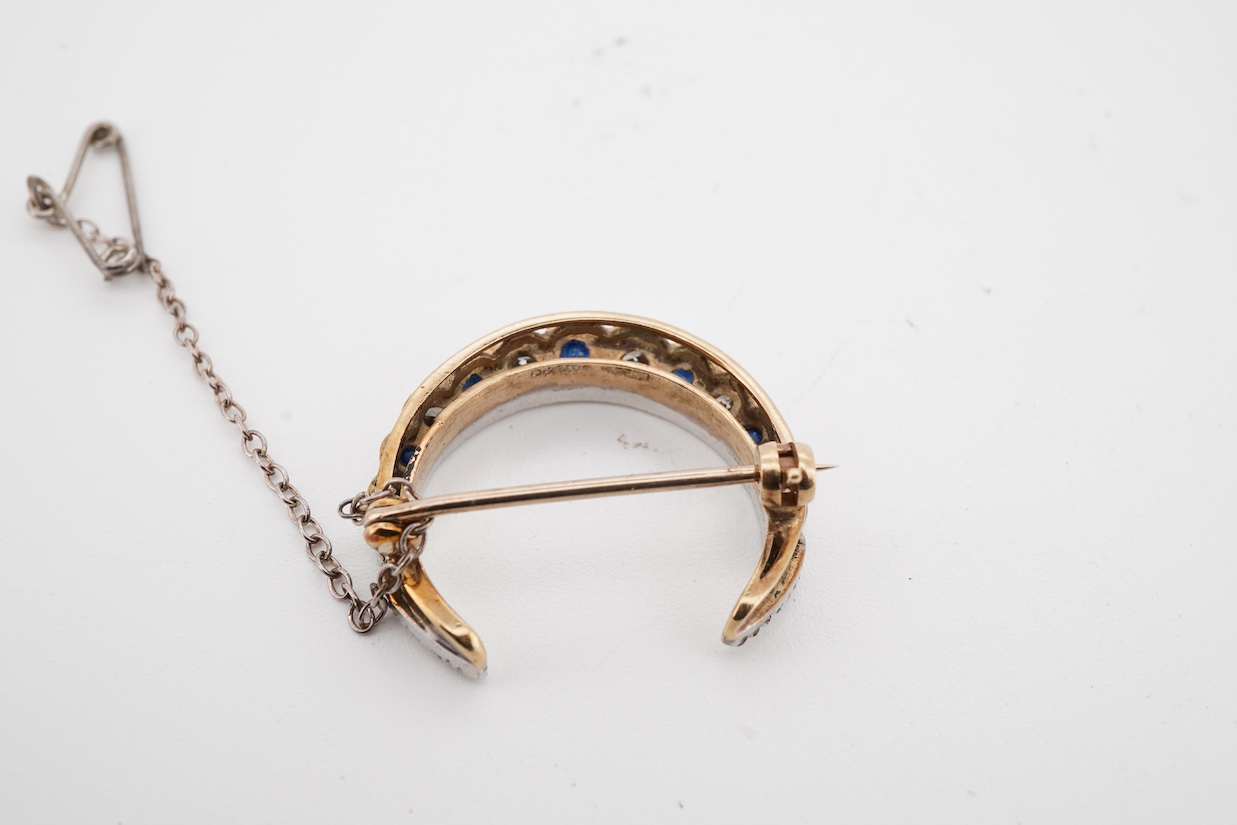 A 1970's Edwardian style 9ct gold, graduated sapphire and diamond set crescent brooch, 24mm.